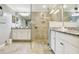 Bathroom with large glass shower, neutral gray walls, white cabinets and tile floors at 5916 Wake Forest Run # 101, Bradenton, FL 34211