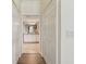Hallway with closet leading to a bathroom with dual sinks, white cabinets and tile floors at 5916 Wake Forest Run # 101, Bradenton, FL 34211