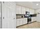 Bright kitchen featuring stainless steel appliances, granite countertops, and white cabinetry at 5916 Wake Forest Run # 101, Bradenton, FL 34211