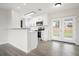 Modern kitchen with white cabinetry, stainless steel appliances, breakfast bar, and French doors leading to the backyard at 609 Carmel Rd, Venice, FL 34293