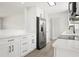 Spacious kitchen with stainless steel refrigerator, white cabinets, modern countertops, and new flooring at 609 Carmel Rd, Venice, FL 34293