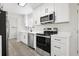 Updated kitchen featuring stainless steel appliances, sleek white cabinetry, and stylish countertops at 609 Carmel Rd, Venice, FL 34293