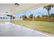 Relaxing screened patio overlooking a large fenced-in yard with a tropical palm tree at 609 Carmel Rd, Venice, FL 34293