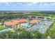 Aerial view showcasing tennis courts, pool, clubhouse, and lush landscaping in a residential community at 6312 41St E Ct, Sarasota, FL 34243
