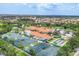Aerial view showcasing tennis courts, bocce ball courts, pool, and clubhouse in a large residential community at 6312 41St E Ct, Sarasota, FL 34243
