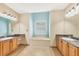 Bathroom featuring a large soaking tub, dual sinks, and granite countertops at 6312 41St E Ct, Sarasota, FL 34243