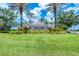 Welcoming community entrance featuring lush landscaping, a decorative sign, and palm trees at 6312 41St E Ct, Sarasota, FL 34243