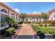Beautiful courtyard featuring lush landscaping, a water feature, and archway in a building with a terracotta roof at 6312 41St E Ct, Sarasota, FL 34243