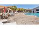 Community pool with lounge chairs and umbrellas, surrounded by lush landscaping at 6312 41St E Ct, Sarasota, FL 34243