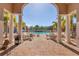 Picturesque pool patio framed by elegant columns and palm trees, offering a tranquil space for residents at 6312 41St E Ct, Sarasota, FL 34243