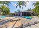Tropical backyard with a pool, spa, and outdoor dining area near the water at 6806 Palm Dr, Holmes Beach, FL 34217