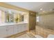 Bright bathroom featuring double vanity with white cabinetry, quartz counters, and tiled walk-in shower at 6806 Palm Dr, Holmes Beach, FL 34217