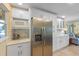 Bright kitchen featuring stainless steel appliances, including a refrigerator and microwave, and white cabinets at 6806 Palm Dr, Holmes Beach, FL 34217