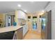 Well-lit kitchen featuring stainless steel appliances, white cabinets, and a view of the backyard through a glass door at 6806 Palm Dr, Holmes Beach, FL 34217