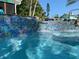 Stunning pool featuring iridescent mosaic tilework and a gentle waterfall feature at 6806 Palm Dr, Holmes Beach, FL 34217