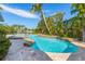 Luxury pool and spa surrounded by lush tropical landscape overlooking the water at 6806 Palm Dr, Holmes Beach, FL 34217