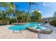 Backyard oasis with a sparkling pool, spa, and lush tropical landscaping at 6806 Palm Dr, Holmes Beach, FL 34217