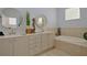 Bright bathroom featuring double sinks, soaking tub, and decorative accents at 695 Rivendell Blvd, Osprey, FL 34229