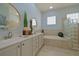 Bright bathroom featuring double sinks, soaking tub, and glass block window at 695 Rivendell Blvd, Osprey, FL 34229