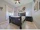 This bedroom with a black bed frame has wood-look floors and plenty of natural light at 695 Rivendell Blvd, Osprey, FL 34229