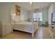 This serene main bedroom features beachy decor and a four-poster bed and wood-look flooring at 695 Rivendell Blvd, Osprey, FL 34229