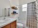Well-lit bathroom featuring a vanity sink, decorative shelves and a shower with curtain at 7026 43Rd E Ave, Palmetto, FL 34221