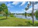 Lush lawn leading to a tranquil lake with a fountain in the distance at 7026 43Rd E Ave, Palmetto, FL 34221