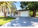 Charming single-story home featuring a well-maintained lawn, a palm tree, and an attached two-car garage at 7164 Gama Ct, North Port, FL 34287
