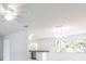 Open-concept living space with a ceiling fan, large windows, and an adjacent kitchen featuring stainless steel appliances at 7164 Gama Ct, North Port, FL 34287
