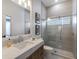 Tiled bathroom featuring a marble countertop, stylish sink, and glass-enclosed shower at 7211 Marston Ct, University Park, FL 34201