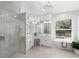 Bright bathroom showcasing a glass enclosed shower and a freestanding soaking tub under a window at 7211 Marston Ct, University Park, FL 34201