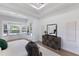 Bright bedroom featuring a bay window, a private door, and a modern dresser with large mirror at 7211 Marston Ct, University Park, FL 34201