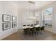 Dining room with wainscotting detail, modern chandelier, and natural light from several windows at 7211 Marston Ct, University Park, FL 34201