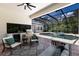 Outdoor living area with a screened pool and spa, grill area, ceiling fan and comfortable seating at 7211 Marston Ct, University Park, FL 34201