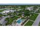 Aerial view of condo community with a pool, lush greenery, and serene lake views at 7301 W. Country Club N Dr # 108, Sarasota, FL 34243