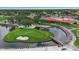 Aerial view of the golf course pond with fountain, landscaping, and nearby clubhouse at 7301 W. Country Club N Dr # 108, Sarasota, FL 34243