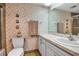 Charming bathroom with whimsical seashell wallpaper and practical layout featuring toilet, sink, and shower at 7301 W. Country Club N Dr # 108, Sarasota, FL 34243