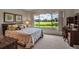 Bright bedroom featuring a large window overlooking scenic views, comfortable bed, and a functional desk at 7301 W. Country Club N Dr # 108, Sarasota, FL 34243