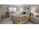 Cozy bedroom featuring floral bedding, complementary wall art, and a well-lit space with natural light at 7301 W. Country Club N Dr # 108, Sarasota, FL 34243