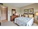 Comfortable bedroom with warm tones, featuring a dresser, mirror, and a cozy bed with soft lighting at 7301 W. Country Club N Dr # 108, Sarasota, FL 34243