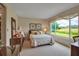 Cozy bedroom with a large window, dresser, and comfortable bed overlooking lush outdoor scenery at 7301 W. Country Club N Dr # 108, Sarasota, FL 34243