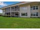 Exterior view of the residential building featuring a covered patio and lush green lawn at 7301 W. Country Club N Dr # 108, Sarasota, FL 34243