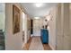 Hallway features tiled floor, wallpaper, and an aqua colored chest, leading to an open door at 7301 W. Country Club N Dr # 108, Sarasota, FL 34243