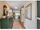 Long hallway with tiled floors, wallpaper, pictures, and chest leading to the living room in this lovely home at 7301 W. Country Club N Dr # 108, Sarasota, FL 34243