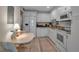 Bright kitchen featuring white cabinetry, granite countertops, and modern appliances with a cozy dining area at 7301 W. Country Club N Dr # 108, Sarasota, FL 34243