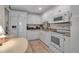 Bright kitchen featuring white cabinetry, granite countertops, and modern appliances with a cozy dining area at 7301 W. Country Club N Dr # 108, Sarasota, FL 34243