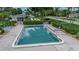 Community pool surrounded by mature landscaping with lounge chairs on the pool deck at 7301 W. Country Club N Dr # 108, Sarasota, FL 34243
