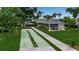 Shuffleboard courts next to cabana area surrounded by lush, tropical greenery and trees at 7301 W. Country Club N Dr # 108, Sarasota, FL 34243