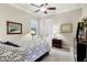 Comfortable bedroom with a ceiling fan, soft carpet, neutral walls, and framed artwork at 7605 Haddington Cv, Lakewood Ranch, FL 34202