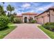 Beautiful home features a tile roof, pristine landscaping, and a brick driveway for added curb appeal at 7605 Haddington Cv, Lakewood Ranch, FL 34202